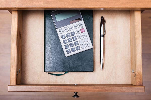 Mesa com caderno, calculadora e notas de orçamento